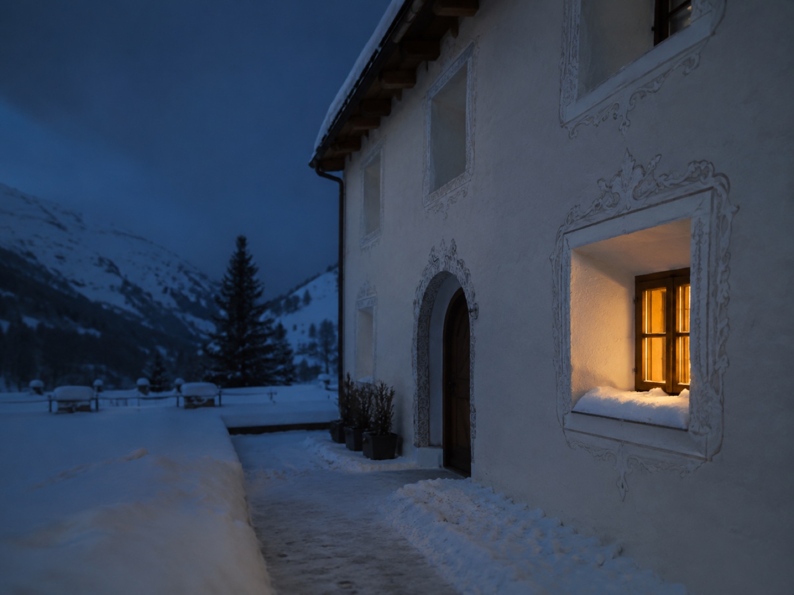 Engadinerhaus zur blauen Stunde, ein Fenster warm erleuchtet
